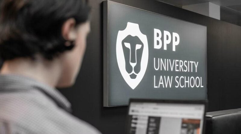 Student at BPP University Law School with scholarship application on laptop screen in front of university logo